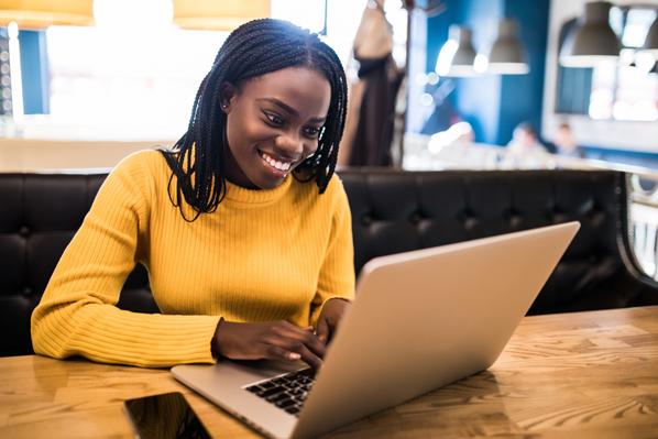 Young african woman typing on laptop